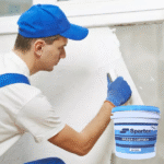 Homem aplicando massa corrida na parede.